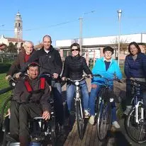 Foto di gryppo di alcuni voontari durante la prima prova su strda della bici-carrozzina